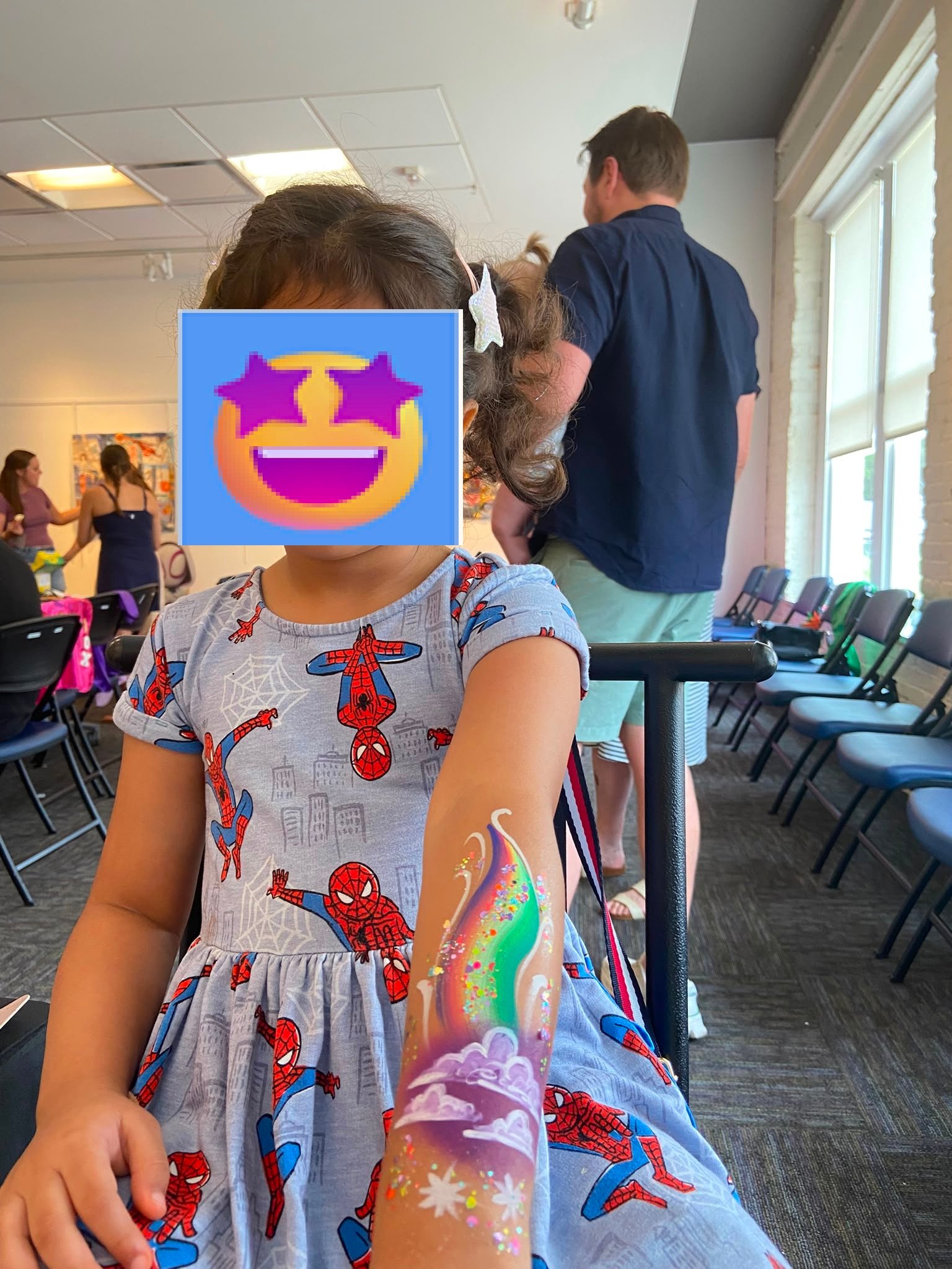 Vibrant rainbow and clouds arm face paint design in Apex